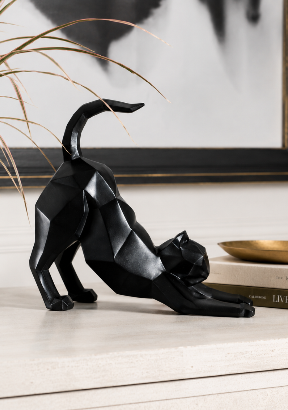 Aravalii Stretching Cheshire Cat whimsical resin sculpture variant in gold finish on a bedside table