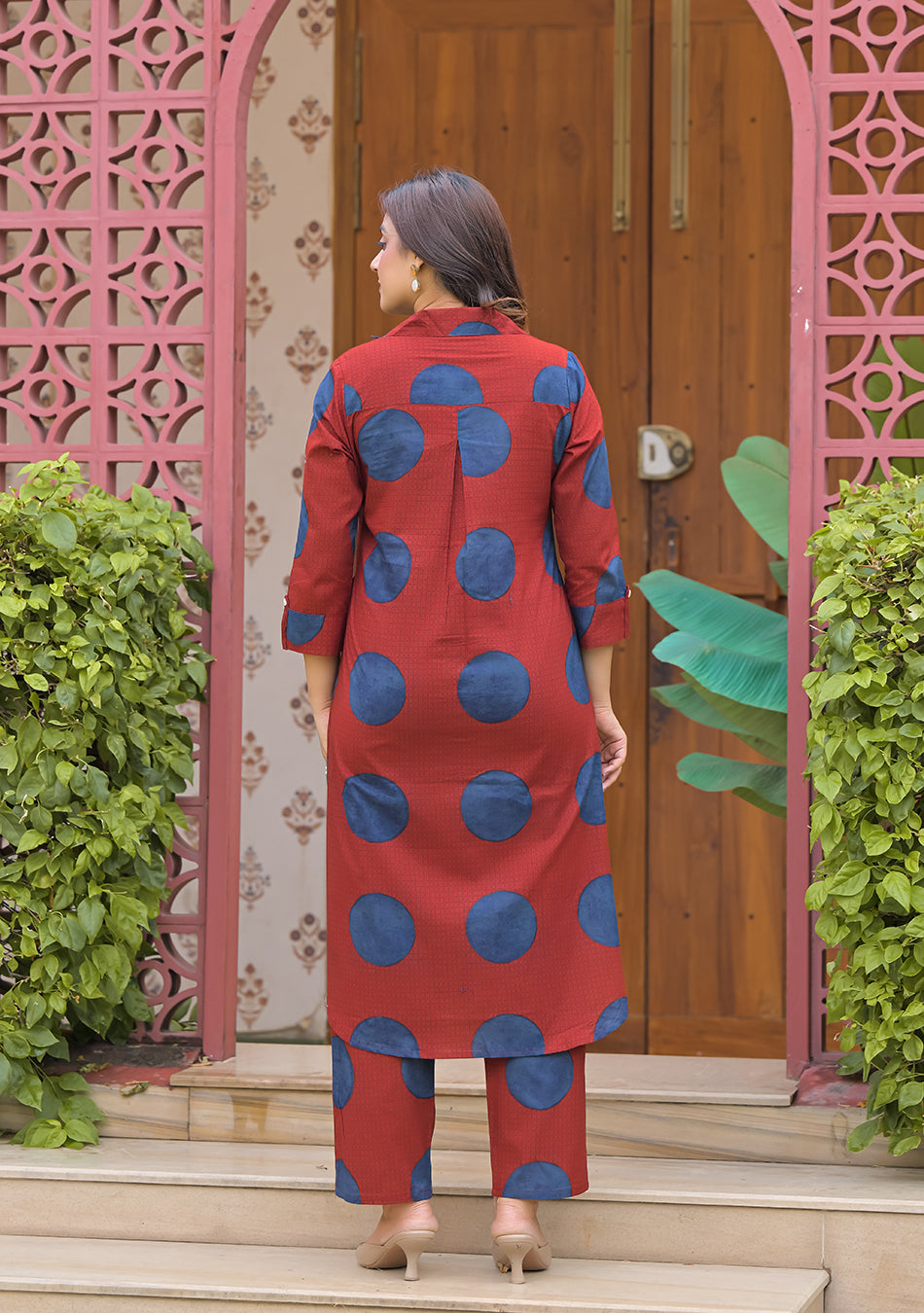 Back view of relaxed A-line rust red printed cotton kurta with matching straight pants