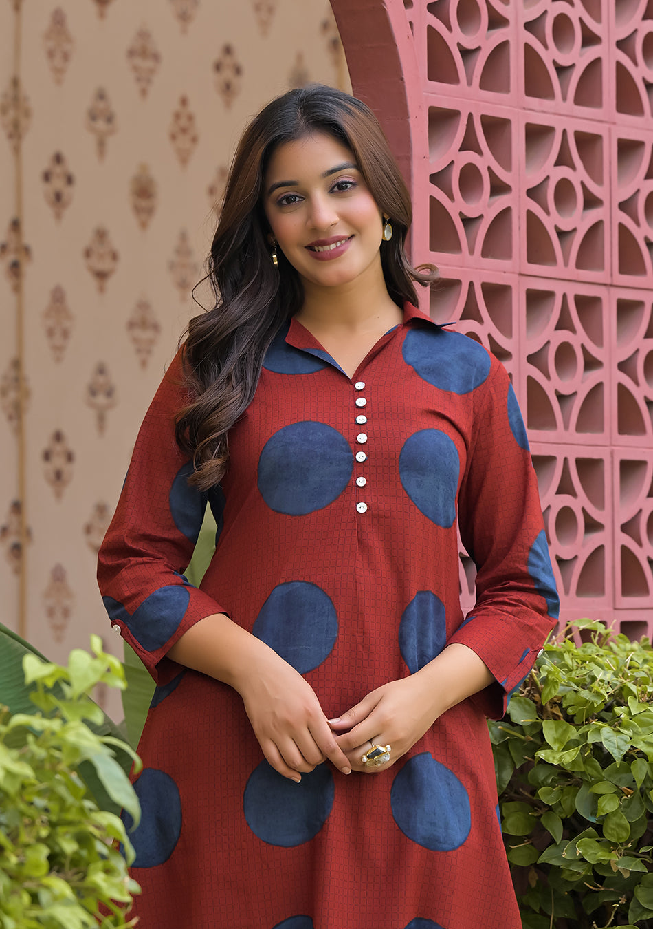 Close-up of collared V-neck detailing and indigo circular print on rust cotton fabric
