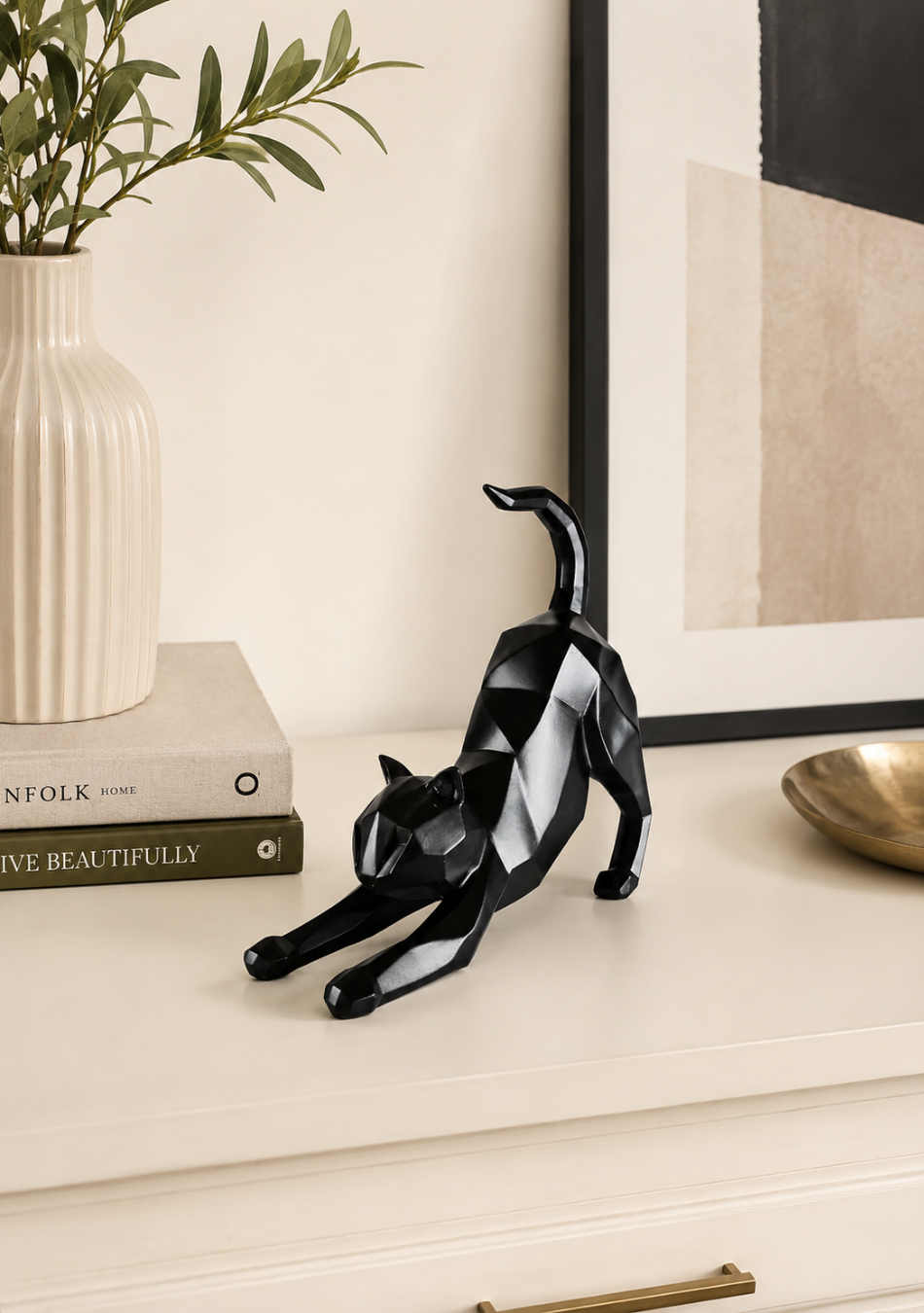 Aravalii Stretching Cheshire Cat whimsical resin sculpture variant in gold finish on a bedside table