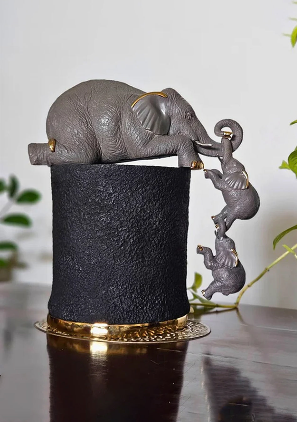 Aravalii Mother's Reach resin figurine featuring a mother and child sculpture with elegant electroplated metal details on a living room shelf
